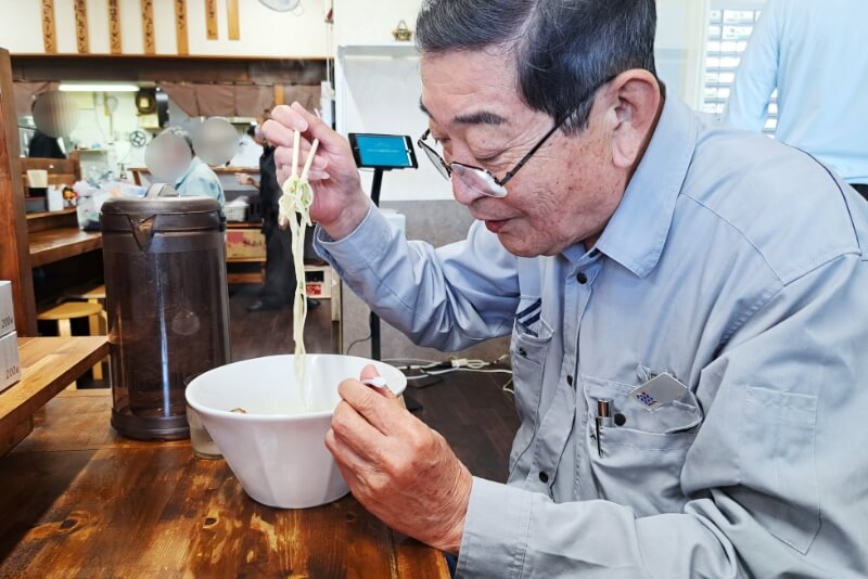 ラーメンを食べている男性